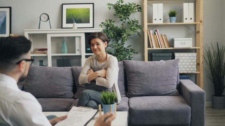 A professional psychologist consults with a female patient in a comfortable office environment.