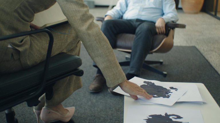 A therapy session with focus on inkblot psychology test and patient interaction.